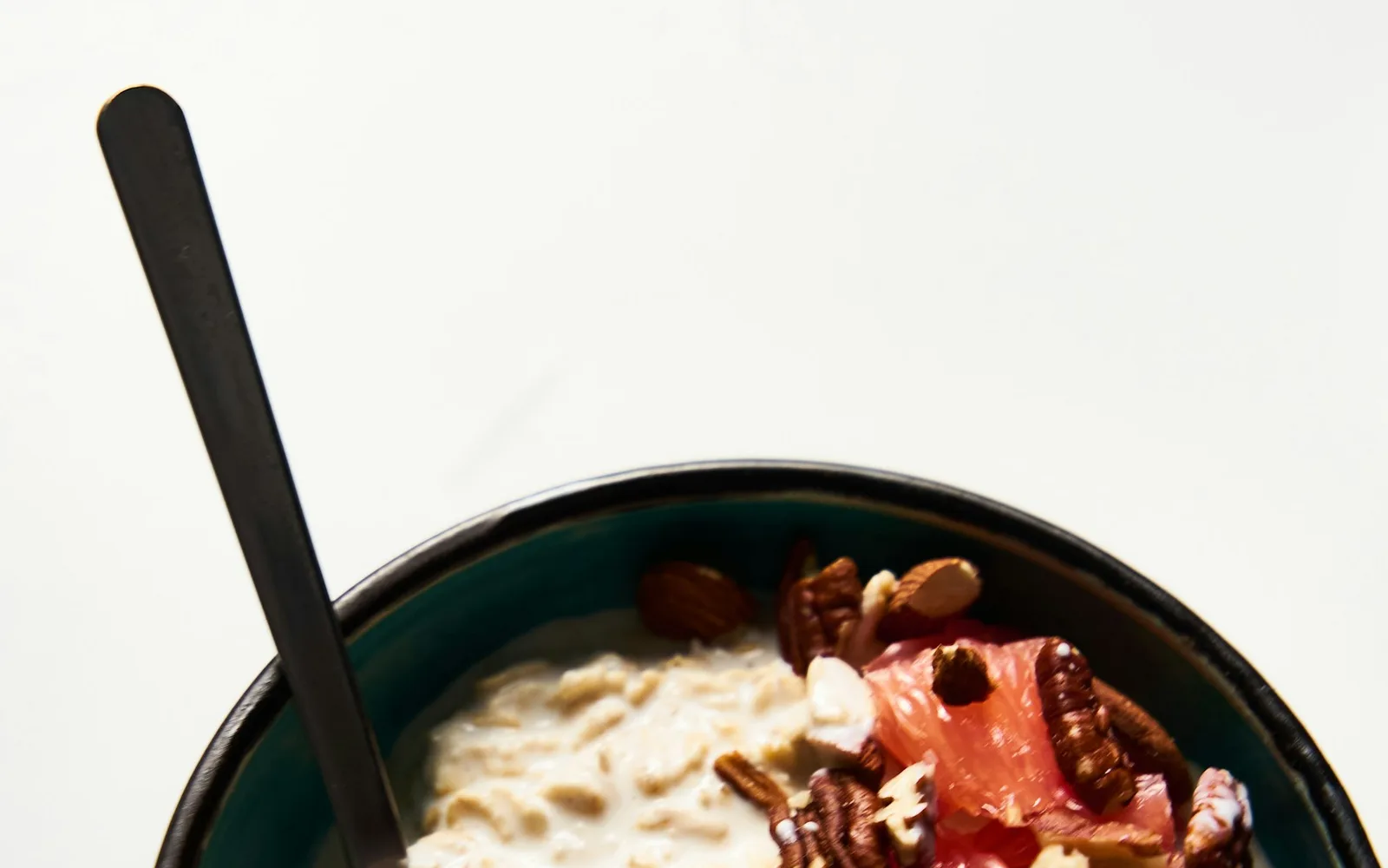 A bowl of oatmeal with fruit and nuts