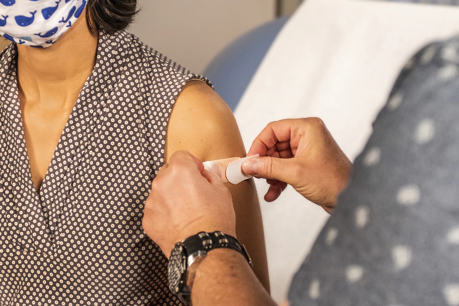 A clinician placing a plaster after a vaccination
